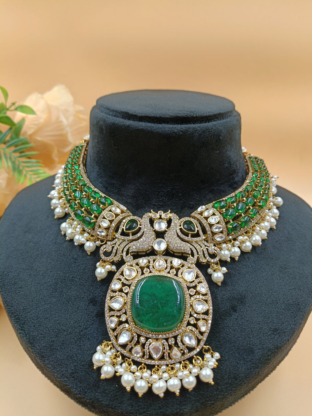 An opulent emerald and pearl necklace featuring two intricately set peacocks, radiating elegance and regal charm.