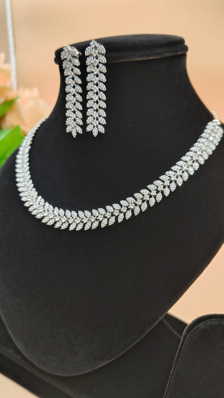 A necklace and earrings displayed elegantly on a black stand, showcasing their intricate design and craftsmanship.