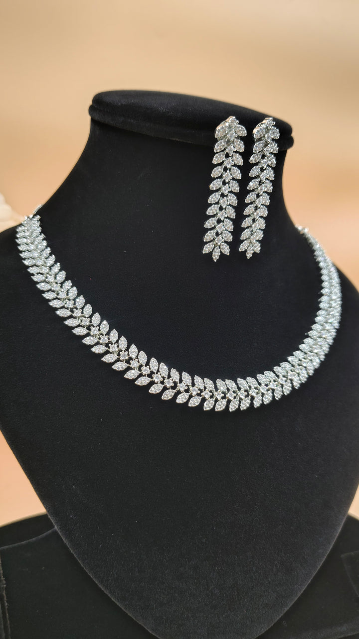 A necklace and earrings displayed elegantly on a black stand, showcasing their intricate design and craftsmanship.